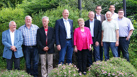 Das Foto zeigt eine Gruppe von Personen inmitten grüner Sträucher